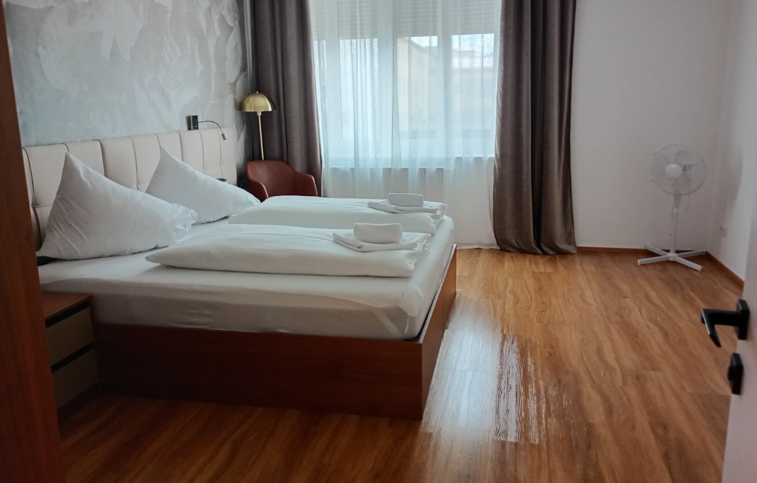 Sorgfältig vorbereitetes Schlafzimmer mit frisch bezogenem Bett